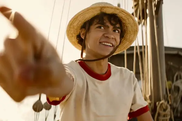 Luffy in One Piece in a straw hat with his finger pointing just past camera