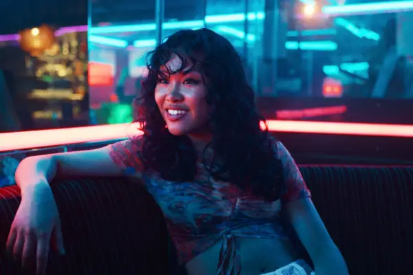 Issy sat talking to Mia at a karaoke bar