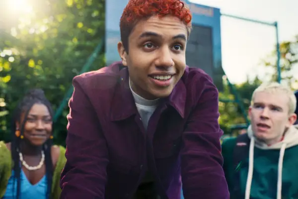 Will kneeling on the grass and smiling, with Becca and Cam sat behind him