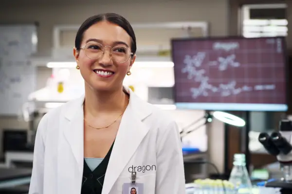 Luna standing in the lab wearing a white lab coat with a smile on her face
