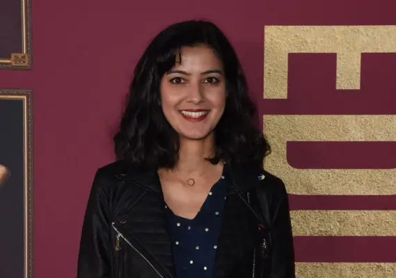 Rakhee Thakrar smiling into camera