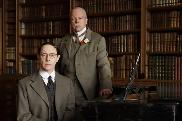 Reece Shearsmith and Steve Pemberton wear grey suits and pose in an antique library setting