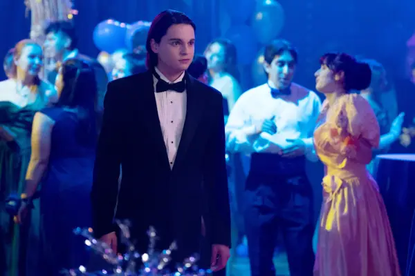 Max Burkholder as John Bennett wearing a tuxedo at a school dance in Ted