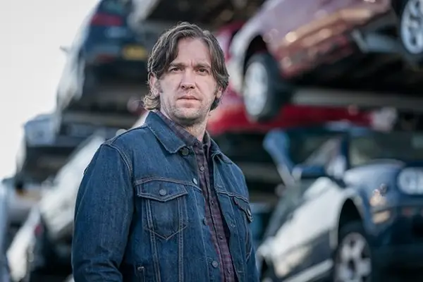 Eve Hewson in Bad Sisters, with her arms up and a wine glass balanced on her head