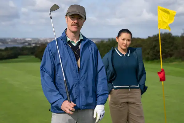 Barry Ward as Fergal and Thaddea Graham as Una, stood on a golf course