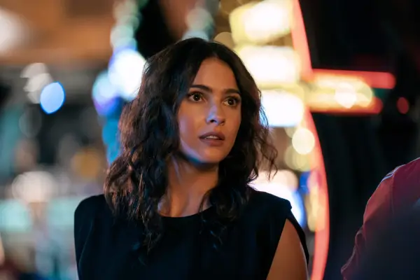 Close-up of Ava in a casino wearing a black dress