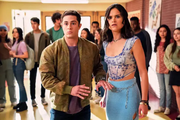 Ben standing next to Margot in the school hallway with a crowd of students gathered behind. They look shocked