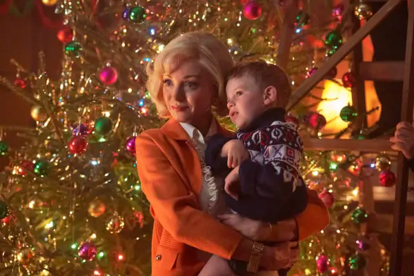 Trixie holding Jonty in front of a Christmas tree