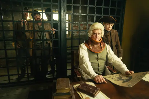 Jonathan Wild sat in a jail, wearing a neck brace