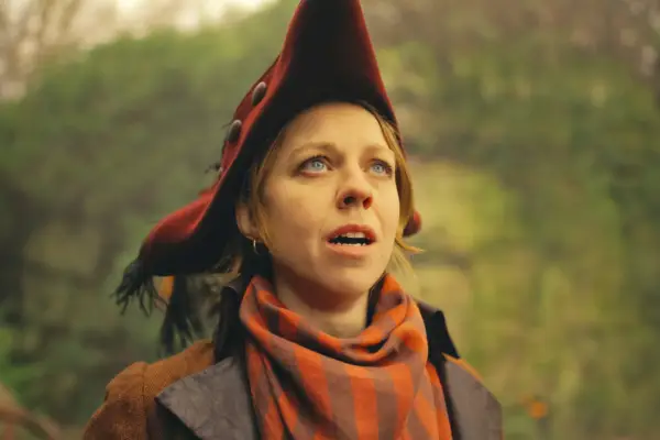 Nell Brazier wearing an orange hat, looking up