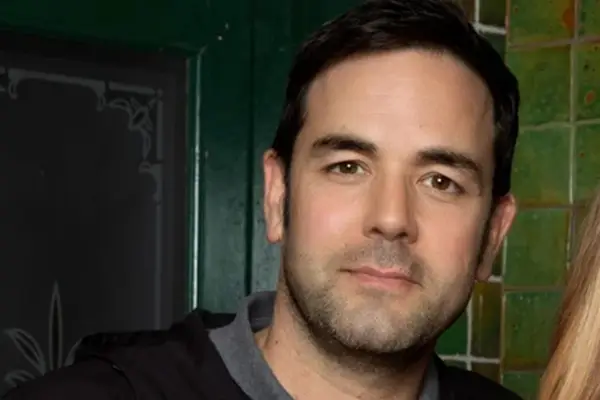 Aaron McCusker as Ben Driscoll smiling in close-up for Coronation Street.