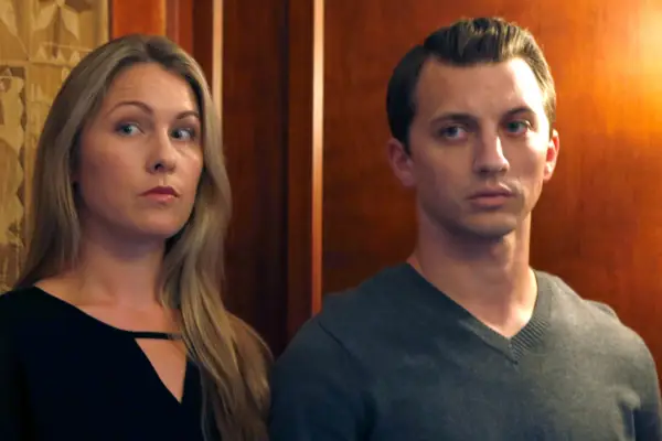 Denise Huskins and Aaron Quinn standing together in front of a brown wall