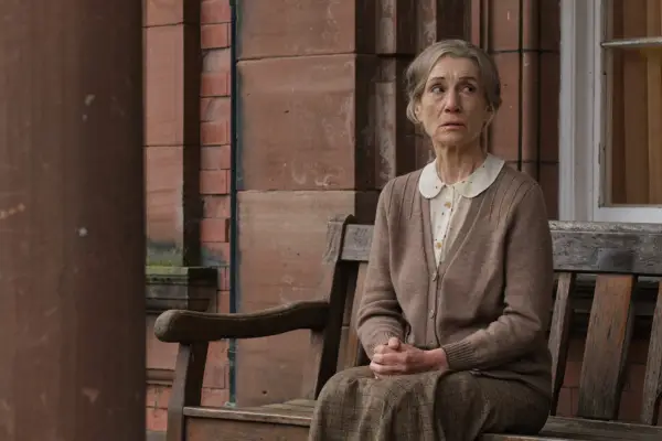 Harriet Walter as Elsie Leach in Archie sitting on a bench.