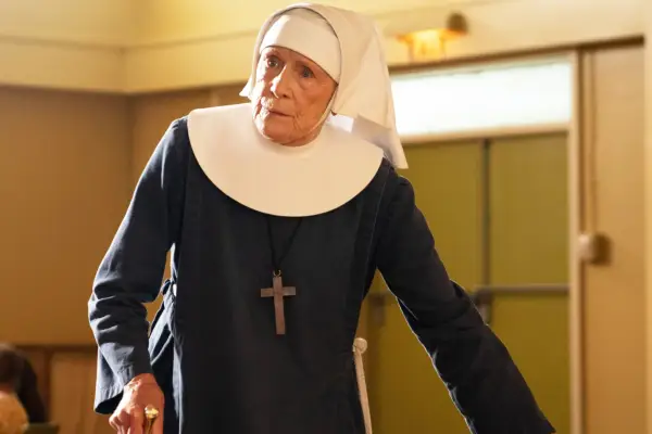 Sister Monica Joan dressed in her nuns uniform leaning on a chair