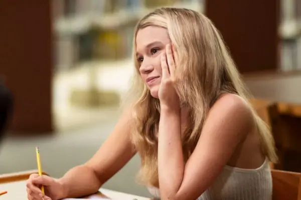 Rain Spencer as Taylor, sat on a chair, head leaning on her hand