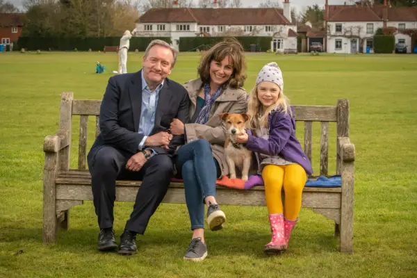 Fiona Dolman, Neil Dudgeon and Isabel Shaw in Midsomer Murders sitting on a bench smiling into camera