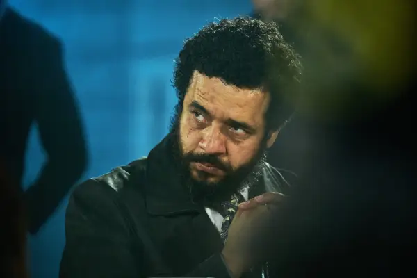 Baem sat at a table, looking to his left