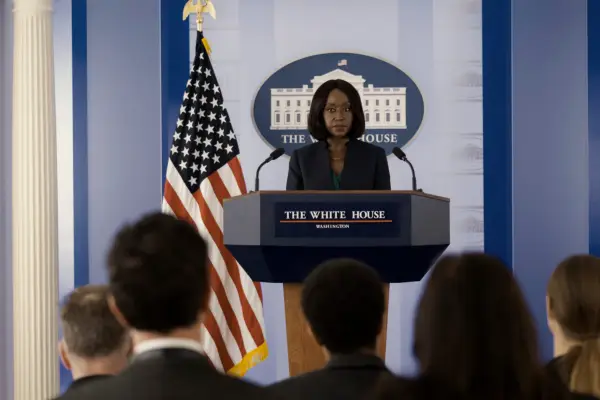 Nana Mensah as Billie Appiah in The Diplomat, stood at a podium in front of the press at the White House.