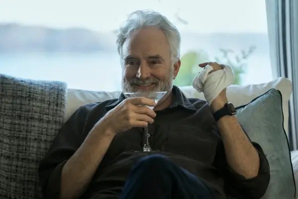 Bradley Whitford and Todd Penn in The Diplomat, with his hand in a bandage and holding a cocktail glass in the other.