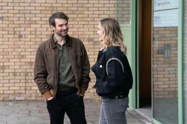 Charlie Cox as Michael Kinsella, stood outside a building and smiling while talking to Danielle Galligan as Molly in Kin season 2