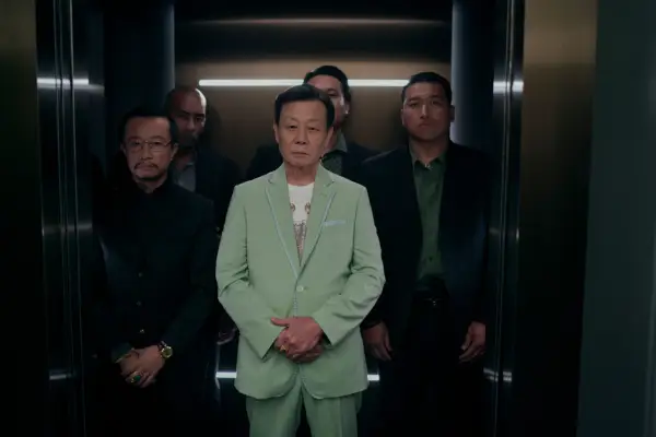 Zhan Wang as Yuan and Johnny Kou as Big Sun in The Brothers Sun standing in a lift wearing suits.
