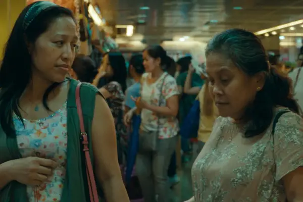 Amelyn Pardenilla as Puri and Ruby Ruiz as Essie in Expats talking in a crowd of people in a market.