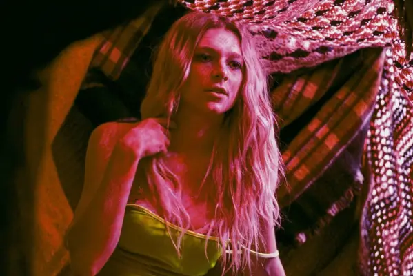 Hunter Schafer as Jules Vaughn in Euphoria, lit up in pink