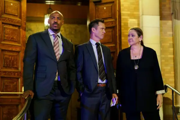 Mehcad Brooks as Det. Jalen Shaw, Jeffrey Donovan as Det. Frank Cosgrove and Camryn Manheim as Lt. Kate Dixon in Law & Order gathered by a set of large wooden doors
