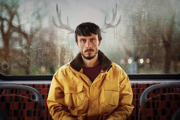Donny sat on the back seat of a bus, on the top deck, with condescension in the shape of antlers on the window behind him