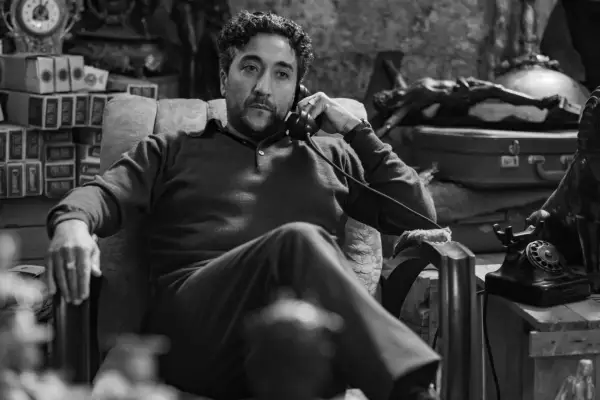Renato Solpietro sat in a chair as Carl in a black-and-white still from Ripley.