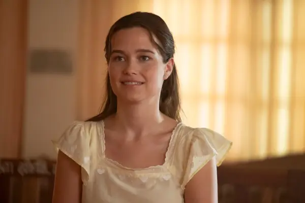 Sarah Catherine Hook as Piper Ratliff smiling in a cream blouse in The White Lotus season 3.