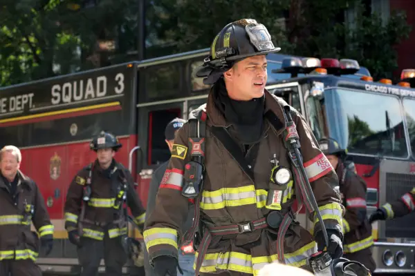 Taylor Kinney as Kelly Severide in Chicago Fire in firefighter uniform with others in the background