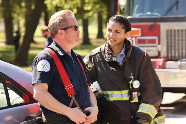 Miranda Rae Mayo plays Lieutenant Stella Kidd in Chicago Fire, wearing her uniform and talking to Mouch, with a fire engine stood behind