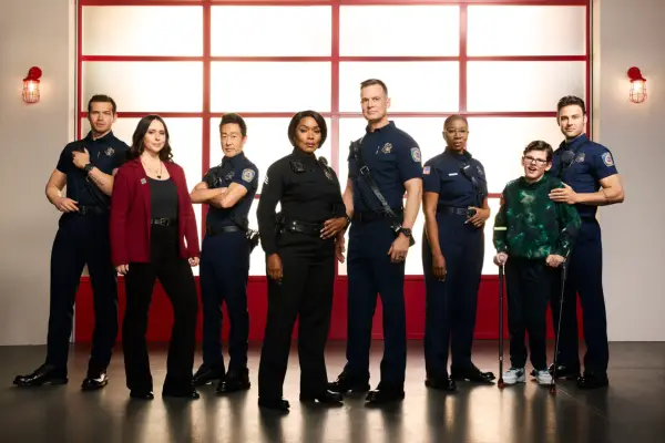 Oliver Stark as Evan Buck Buckley, Jennifer Love Hewitt as Maddie Kendall, Kenneth Choi as Howie Chimney Han, Angela Bassett as Athena Grant, Peter Krause as Bobby Nash, Aisha Hinds as Henrietta Hen Wilson, Gavin McHugh as Christopher Diaz, and Ryan Guzman as Eddie Diaz in 911 standing in a line looking into camera