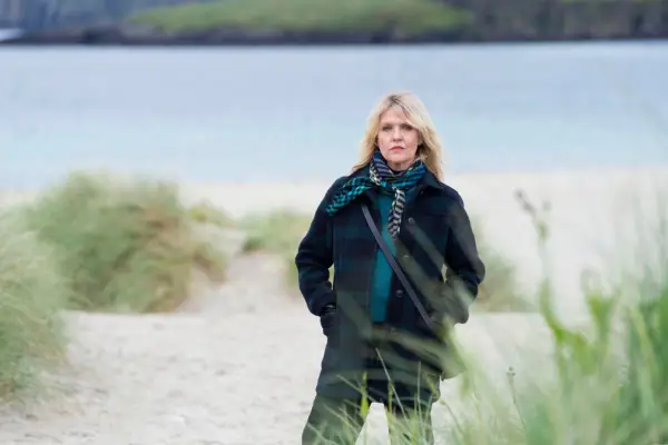 Ashley Jensen as DI Ruth Calder, standing on the beach with her hands in her pockets