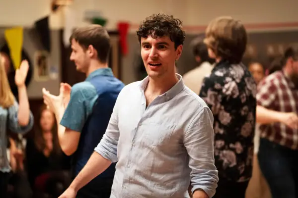 Angus Miller plays Donnie, dressed in a blue shirt at a party