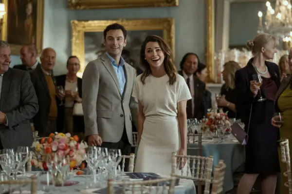 Aidan Turner as Callum Ellis and Keri Russell as Kate Wyler in The Diplomat, stood together and smiling at an event.