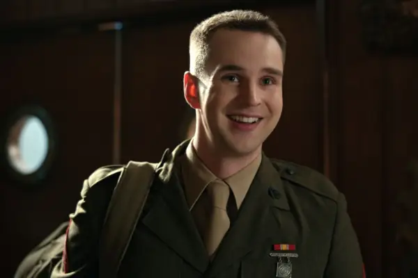 Grayson Gurnsey as Ricky. He is smiling and wearing a green army uniform.