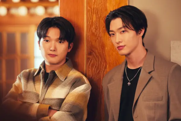 Minyeong Choi as Dae Heon Kim and Sang Heon Lee as Min Ho Moon, stood next to one another, leaning against a wooden backdrop