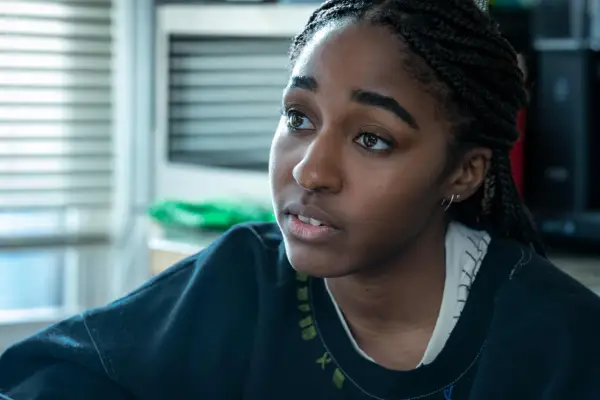 Ayo Edebiri as Sydney Adamu in The Bear sitting in a navy jumper