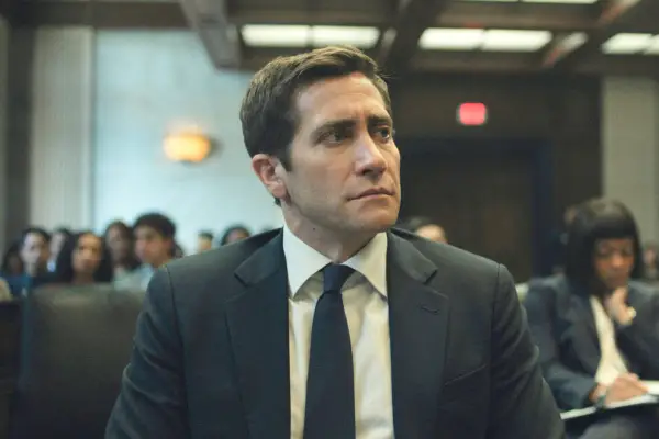 Jake Gyllenhaal in Presumed innocent wearing a suit and sat in a courtroom