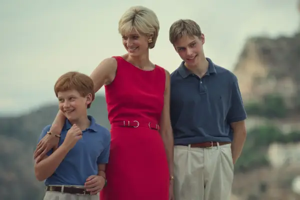Princess Diana (Elizabeth Debicki), Prince Harry (Fflyn Edwards) and Prince William (Rufus Kampa) in The Crown, stood together smiling