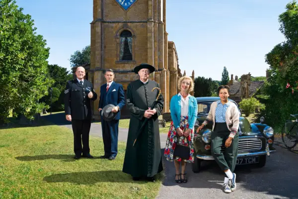 The cast of Father Brown stood in front of a church.