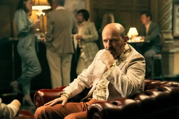 Panesso sat down in a busy room, wearing a cream suit jacket, looking contemplative