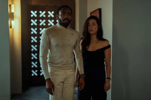 Donald Glover and Maya Erskine as they appear in Mr & Mrs Smith, looking a bit scruffy having just been in a fight
