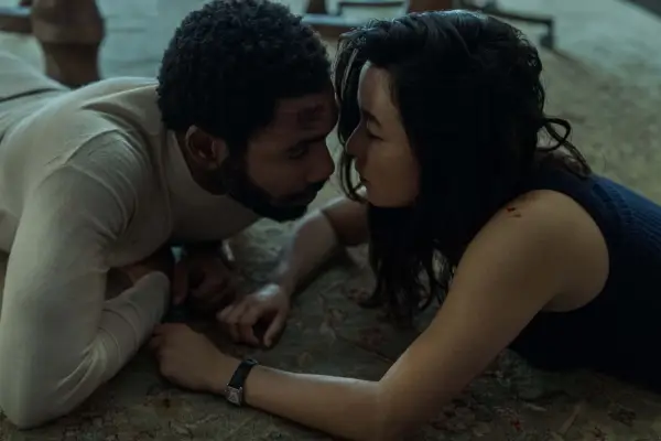Donald Glover and Maya Erskine lying on the ground, with their faces very close to one another in a scene from Mr & Mrs Smith