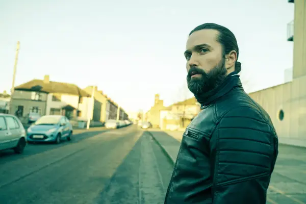 Emmett J Scanlan as Jimmy Kinsella, standing in the street, looking to his left