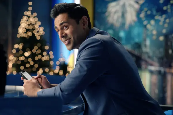 Maggie at a social event, standing at a table, looking across the room