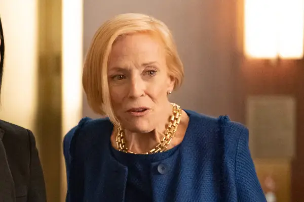 Cybil Richards wearing a navy suit and a chunky gold necklace