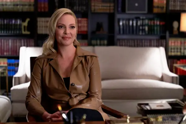 Katherine Heigl as Samantha Wheeler in Suits, sat in an office and wearing a brown jacket
